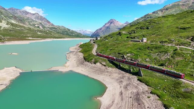 red swiss train in Swiss Alps. famous Lake Bianco on way to St. Moritz. Switzerland summer tourism.