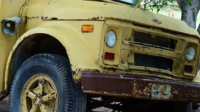 Approaching a parked yellow truck that is rusting