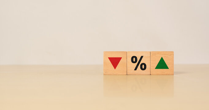 Wooden blocks with down arrow, percent symbol, and up arrow, representing financial indicators, percentage change, economic growth and decline, profit and loss, and business performance analysis