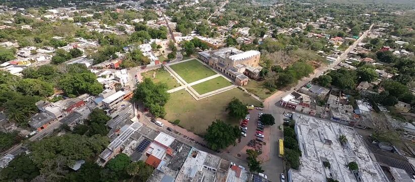 FPV drone flight over colonial city center, tropical architecture and historic plaza, aerial view of colorful buildings, streets and local culture, cinematic footage of authentic Mexican heritage 
