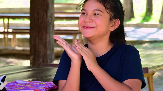 happy Latina girl clapping in the park