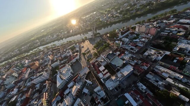 FPV drone aerial flight over tropical city, buildings, avenues and urban rivers, cinematic footage of modern urban landscape and development in southeast Mexico