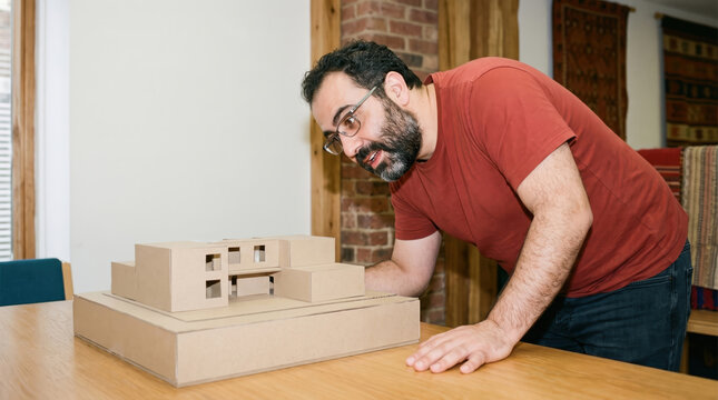 Man studying a cardboard model while wearing AR glasses