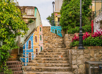 Colorful murals paint the stone steps of a sunny hillside alley. © Kit Leong