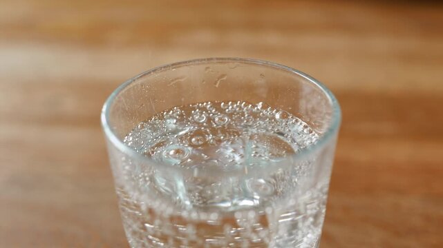 Clear glass with sparkling water displays bubbles rising in three connected frames, emphasizing the drink's refreshing qualities and visual appeal
