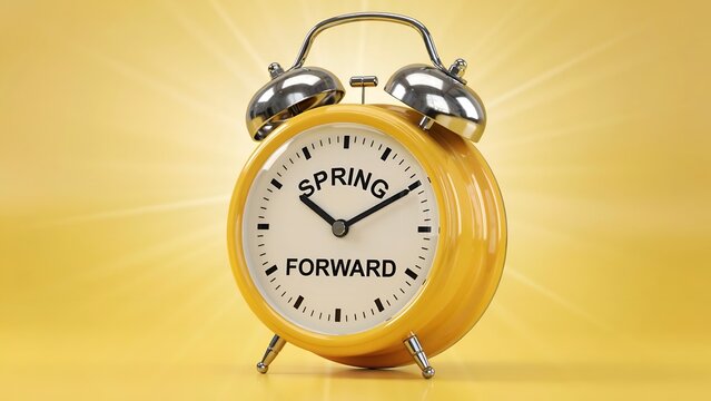 Yellow alarm clock with the words spring forward on its face, symbolizing the start of daylight saving time