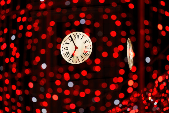 Vintage clock of Puerta del Sol in Madrid floating over blurry red lights, concept of New Year countdown, time passing and Spanish tradition