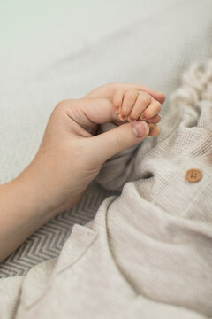 Mother holding her child's newborn infants baby's hand closeup