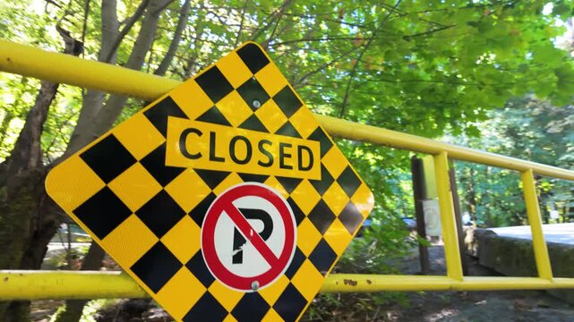 Yellow Park Closed Sign with No Parking Symbol on Metal Gate