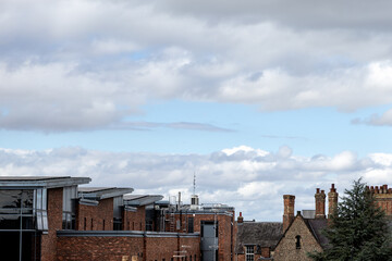 Fototapeta premium Modern and historic brick buildings contrast beneath a dramatic cloudy sky in York, England, highlighting a blend of contemporary and traditional urban architecture