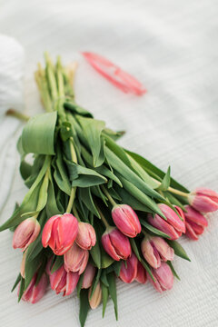 beautiful pink bright tulips on a beige blanket with pink sunglasses