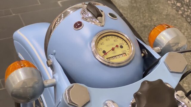 Vintage Motorcycle Speedometer Close Up Top Down View | Retro Blue Headlight Fairing with Chrome Details and Turn Signals | Classic Bike Dashboard