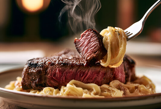 A mouthwatering steak accompanied by pasta is presented on a plate. It's being devoured with a fork.