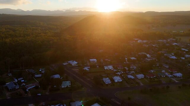 Aerial Sunset Over Rural Town and Distant Mountain Range