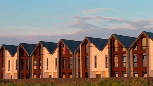 Row of New Townhouses at Sunset Pan Shot | Modern Suburban Residential Development with Gabled Roofs | Real Estate Housing Construction