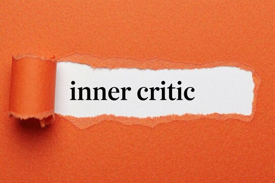 Torn orange paper white background with inner critic text. Concept of mental pressure, self doubt, psychological struggle. Metaphor for negative thoughts, insecurity hidden behind facade. Conceptual