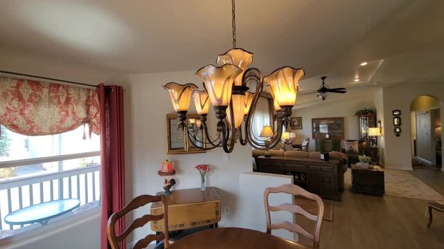 Chandelier over round dining table in warm dining room