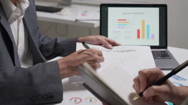 Close Up of Business Colleagues Analyzing Sales Reports and Charts in Office