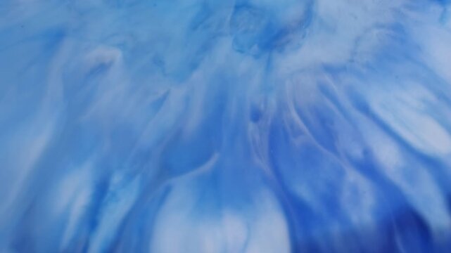 Dye spreading. Ink splash. White pigment spatter on blue art enamel liquid. Spill contrast color opener effect abstract background.
