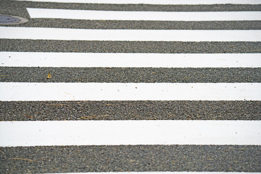 White pedestrian crossing stripes on an asphalt road