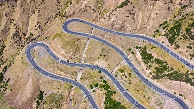 Top-down aerial view of a winding road with hairpin curves on the Duku Highway in Xinjiang, China