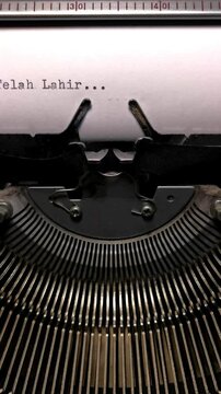 Vertical Macro Shot of Vintage Typewriter Typing "Telah Lahir..." in Indonesian