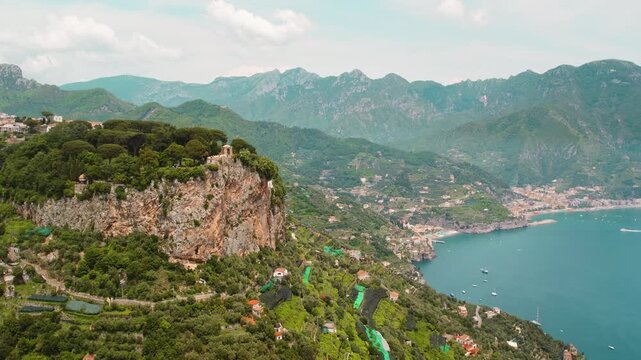 Aerial view of the Amalfi coast with cliffs, greenery, and the coastal town Ravello in summer sunny day.