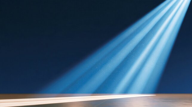 Dramatic blue spotlight beams cutting through dark studio space with glowing floor reflection and floating particles