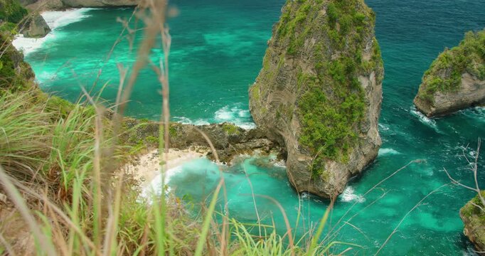 Rock formation rises from turquoise water near Diamond Beach on Nusa Penida Island Indonesia