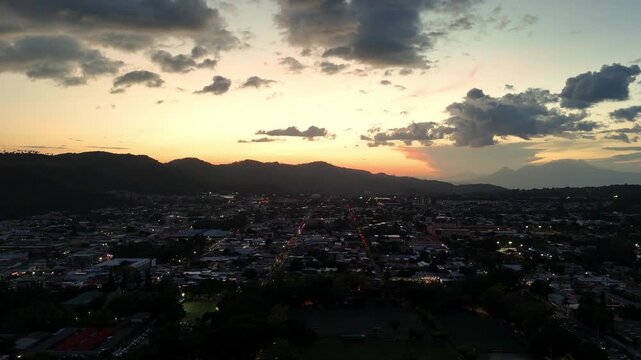 Hermoso atardecer de la ciudad de santa tecla en El Salvador con un hermoso cielo te&ntilde;ido de oro rodeado de edificios y monta&ntilde;as y en el fondo los volcanes de Izalco y Santa Ana