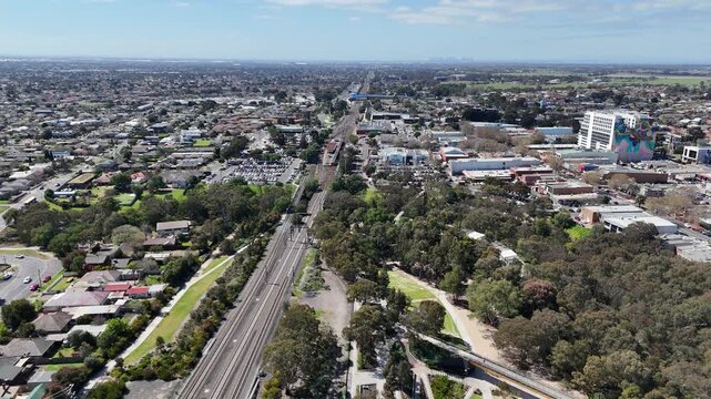 Aerial drone view of Werribee town center, with Werribee railway line, train station, Werribee river running alongside commercial precincts and residential neighborhoods. Melbourne Australia