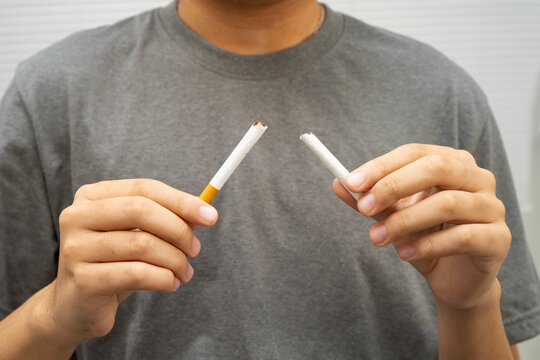 Man holding cigarette, no smoking.