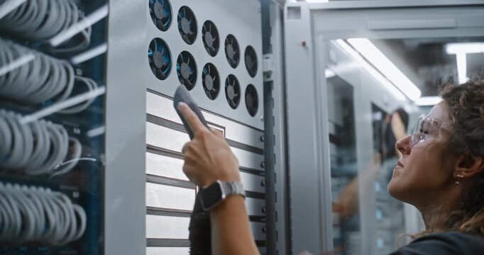 Female Network Administrator Cleans Cooling Fan Grills on Active Server Unit. Routine Facility Upkeep and Physical Security Management Safeguard Enterprise Cloud Servers From Thermal Failure.
