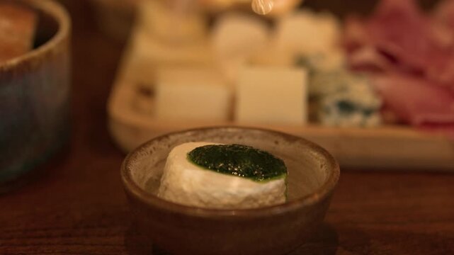 Fresh Italian Tomino Cheese with Green Pesto Sauce in Bowl
