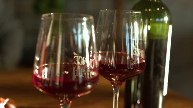 Close Up of Glasses and Bottle of Red Wine on Wooden Table