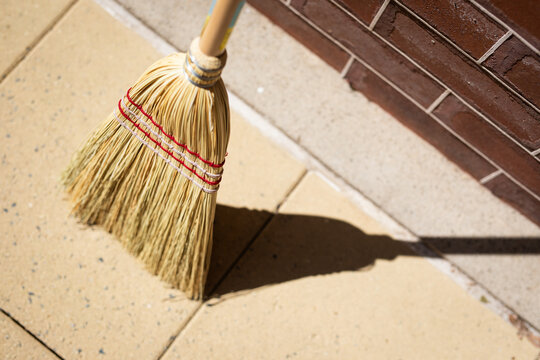 Traditional Straw Broom Against Brick Wall Outdoors