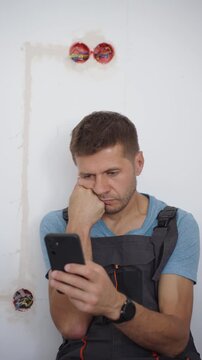 Man searching repair information on phone during renovation