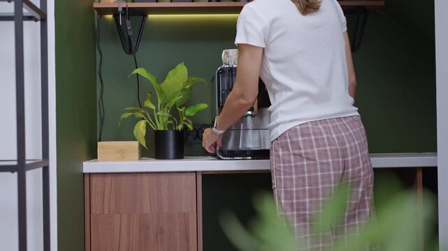 Woman making coffee with coffee machine at home coffee station