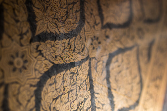 Ancient Thai art gold leaf floral pattern on black lacquer background