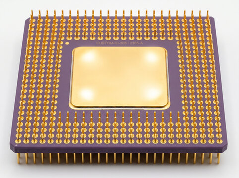 Purple ceramic microprocessor with gold pins and heat spreader for high performance computing.