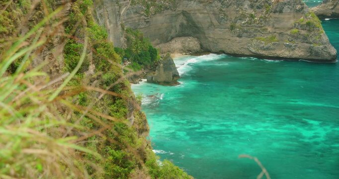 Steep Green Cliffs Meet Bright Turquoise Water At Diamond Beach in Nusa Penida Island Indonesia