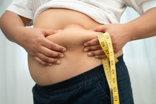 Asian woman use hand to squeeze fat belly big size overweight and obesity.
