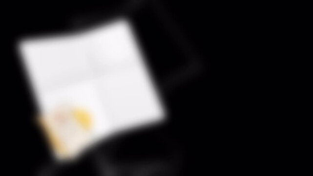 Blank folded paper card mockup with currency and golden coin on black background.