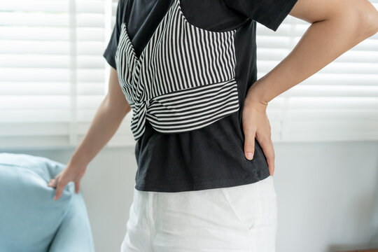 woman holding back while and suffer from unbearable pain health and problems, chronic back pain, backache in office syndrome, scoliosis, herniated disc, muscle inflammation