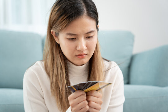 Stressed and headache asian woman with large bills or invoices no money to pay to expenses and credit card debt. shortage, Financial problems, mortgage, loan, bankruptcy, bankrupt, poor, empty wallet