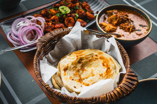 Top view of Kerala paratha chicken curry and prawn roast