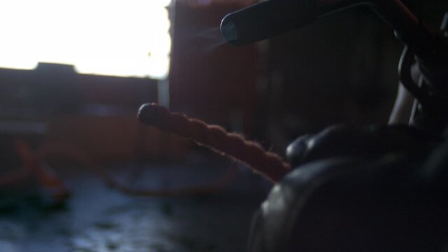 Braided nylon rope edge is heat sealed with propane stove flame by a gloved hand