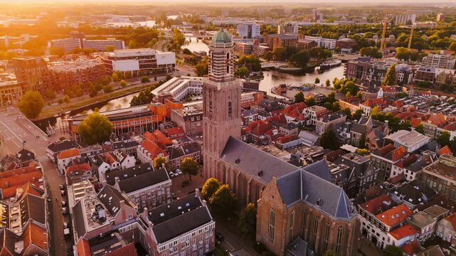 Golden-hour aerial of Zwolle, Netherlands, centered on the Peperbus and Basilica of Our Lady amid historic rooftops, canals and dense city streets.