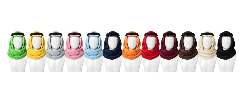 Multiple colorful traditional Arabic keffiyeh scarves displayed on white mannequin heads. Middle Eastern headwear apparel isolated on a white background.