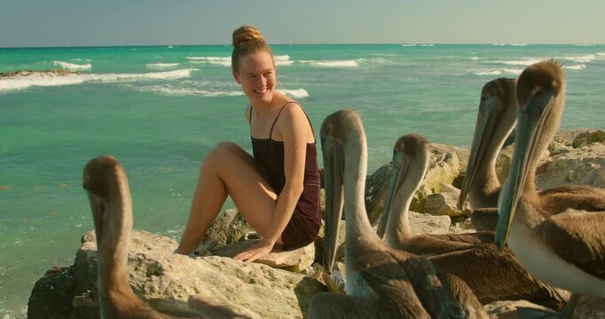 Woman enjoying pelicans during travel on Caribbean coast in Tulum Mexico